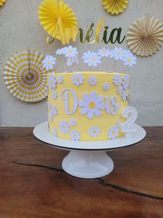 a yellow and white cake sitting on top of a table next to some paper fans