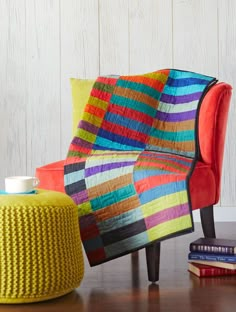 a colorful couch sitting next to a table with a coffee cup on top of it