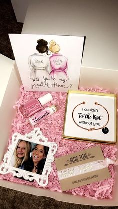 an open box with some cards inside of it and pink flowers in the bottom right corner