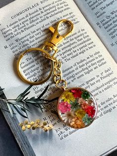 a book with a flower keychain on top of it next to a plant