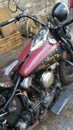 a red and black motorcycle parked next to a building