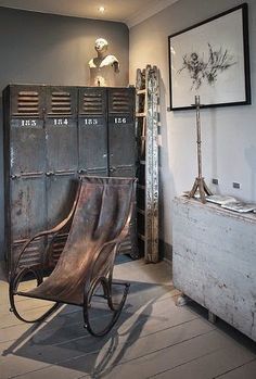 a metal chair sitting next to lockers in a room with wooden floors and white walls