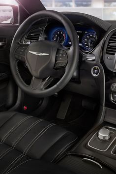 the interior of a car with black leather trims and gauges, steering wheel and dash board