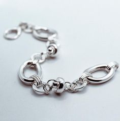 Brand: Argentidea Jewelry Instagram: https://www.instagram.com/gioielli_argentidea/ Measurement: 21cm Weight: 27g. Silver colour 925 silver bracelet, fancy chain made in Italy. The bracelet is composed of 3 large oval links 25 mm long and 17 mm wide, flat round links with an external diameter of 12 mm, and two ''UFO'' components. The components are joined by elegant groups of round and oval links. The bracelet features an oval lobster clasp. The bracelet is the natural color of silver, manually Modern Sterling Silver Charm Bracelet In Silver, Modern Sterling Silver Charm Bracelet With Lobster Clasp, Modern Silver Sterling Silver Charm Bracelet, Sterling Silver Oval Link Charm Bracelet, Elegant Oval Link Sterling Silver Chain Bracelet, Elegant Silver Chain Bracelet With Oval Links, Elegant Sterling Silver Bracelet With Lobster Clasp, Elegant Sterling Silver Charm Bracelet With Lobster Clasp, Sterling Silver Link Bracelets With Silver Chain