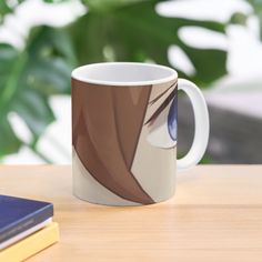 a coffee mug with an anime avatar on it sitting on a table next to a book