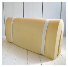 a large yellow pillow sitting on top of a white floor