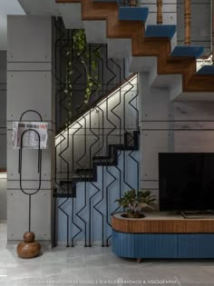 a living room filled with furniture and a flat screen tv next to a stair case