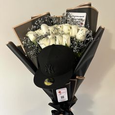 a bouquet of white roses in a baseball cap