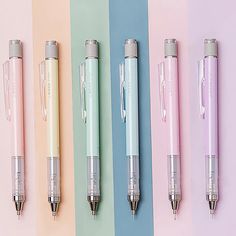 four different colored pens lined up next to each other on a multicolored surface