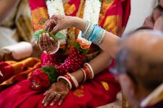 the bride is getting ready to put her hand on the groom's finger as he sits down