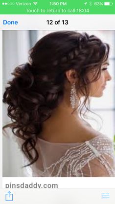 a woman in a wedding dress looking out the window with her hair pulled back into a low bun