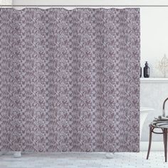 a bathroom with a bathtub and shower curtain in purple tones, along with a chair