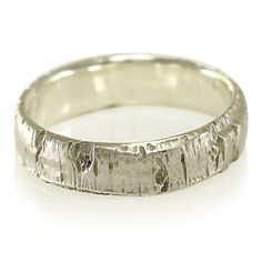 a white gold wedding band that has been carved into the shape of a tree trunk