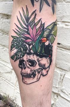 a man's leg with a skull and flowers on it