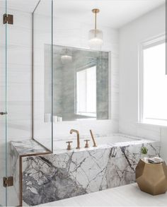 a bathroom with marble and gold fixtures