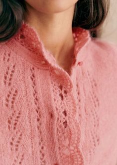 a close up of a woman wearing a pink sweater