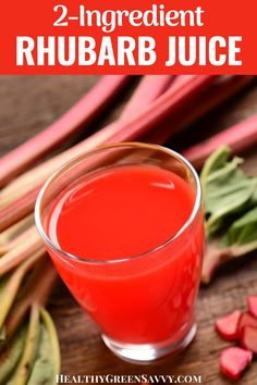 rhubarb juice in a glass next to fresh rhubars on a wooden table