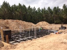 construction workers are working on the foundation of a house in the middle of the woods