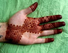 a person's hand with henna tattoos on it