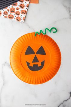 a paper plate with a jack - o'lantern on it sitting on a marble surface