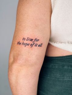 a woman with a tattoo on her arm saying to live for the hope of it all