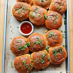 a tray filled with mini sliders covered in cheese and garnished with parsley