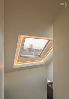 an empty room with a skylight in the corner and a window above it that is lit up