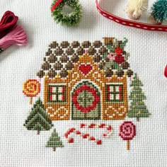 a close up of a cross stitch pattern on a table with other craft supplies and items