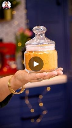 a person holding a glass jar filled with food