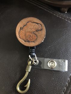 "🔸🔸orders are delayed by a few days this week. Thank you for your patience Bass badge reel, Fisherman gift, id holder, badge clip This badge reel has a brown two tone color veg tanned leather disk attached and adorned with a bass stamped onto the leather. This badge reel has a retractable cord, a swivel 360 degree rotation alligator spring clip, a belt non -swivel clip, or a belt clip with a loop which can attach to a lanyard or necklace, and a clear vinyl strap with an antiqued bronze fish ho Adjustable Badge Reel With Key Clip As Gift, Adjustable Badge Reel With Key Clip Gift, Fishing Gifts For Men, Fisherman Gifts, Santa Clarita, Veg Tan Leather, Fishing Gifts, Hand Lotion, Belt Clip