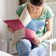 a woman sitting on a chair holding a star pillow