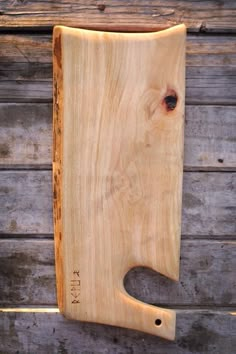 a wooden cutting board sitting on top of a wooden table next to a wood wall