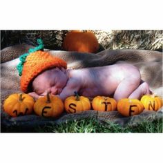 a baby sleeping on top of pumpkins with the words western spelled out in it