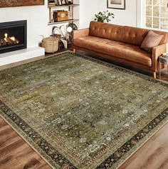 a living room filled with furniture and a rug on top of a hard wood floor