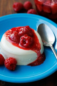 a blue plate topped with whipped cream and raspberries