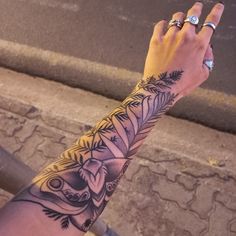 a person with a tattoo on their arm holding up a cell phone to the camera