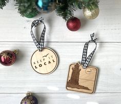 three wooden ornaments hanging from a tree on a white wood background with text keep it local