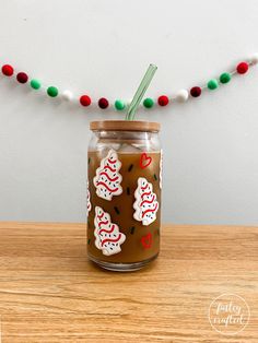 a mason jar with ginger cookies on it sitting on a table next to a string of christmas lights