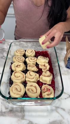 a woman is decorating desserts in a glass dish