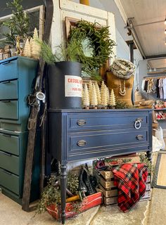 an old dresser is covered in plants and other items