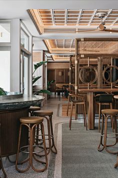 an empty restaurant with lots of wooden chairs and stools in front of the counter