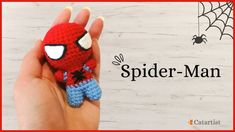 a hand holding a small crocheted spider man