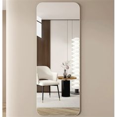 a white chair and table are in front of a large mirror that is hanging on the wall