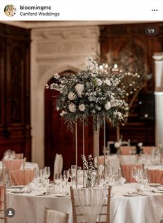 a tall vase with flowers on top of a table