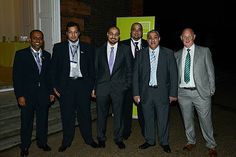 five men in suits and ties standing next to each other on the street at night