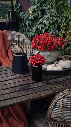 a wooden table topped with a potted plant filled with red berries