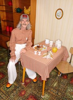 an older woman sitting at a table with food on it