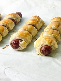 several sausage wrapped in bread on a white surface