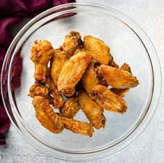 a glass bowl filled with fried chicken wings