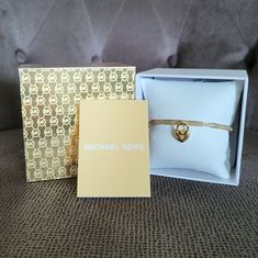 Brand New In Box Michael Kors Dangling Gold Heart Bangle Bracelet Excellent Condition With No Flaws, All Crystals Intact Approx Circumference 7-1/2" Approx Diameter 2-1/2" Approx Heart Drop 5/8" Color Is Yellow Gold Gold Plating Over Stainless Steel Slim Gold Bangle With Pave Crystals And A Dangling Gold Heart With A Crystal In The Center Hinged Bangle With Clasp Closure Please No Trades Or Lowballs! *Ask Any Questions You May Have Prior To Making An Offer Or Purchase Please* Tortoise Shell Bracelet, Pave Bangle, Michael Kors Bracelet, Heart Bangle Bracelet, Rose Gold Logo, Pave Bracelet, Diamond Logo, Silver Heart Bracelet, Girls Stuff